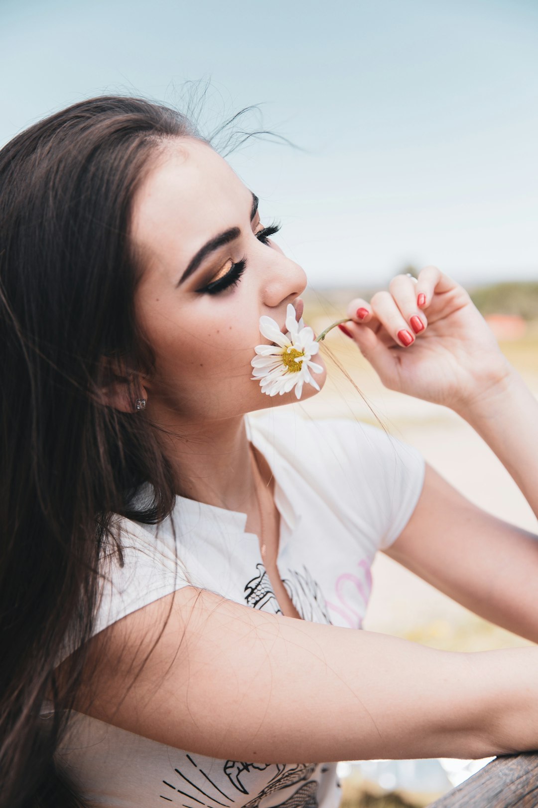Photo by LOGAN WEAVER | @LGNWVR woman in white shirt holding white flower during daytime